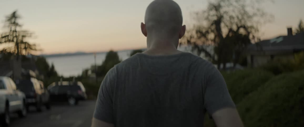Man jogging on a road looking at the sea in front of him
