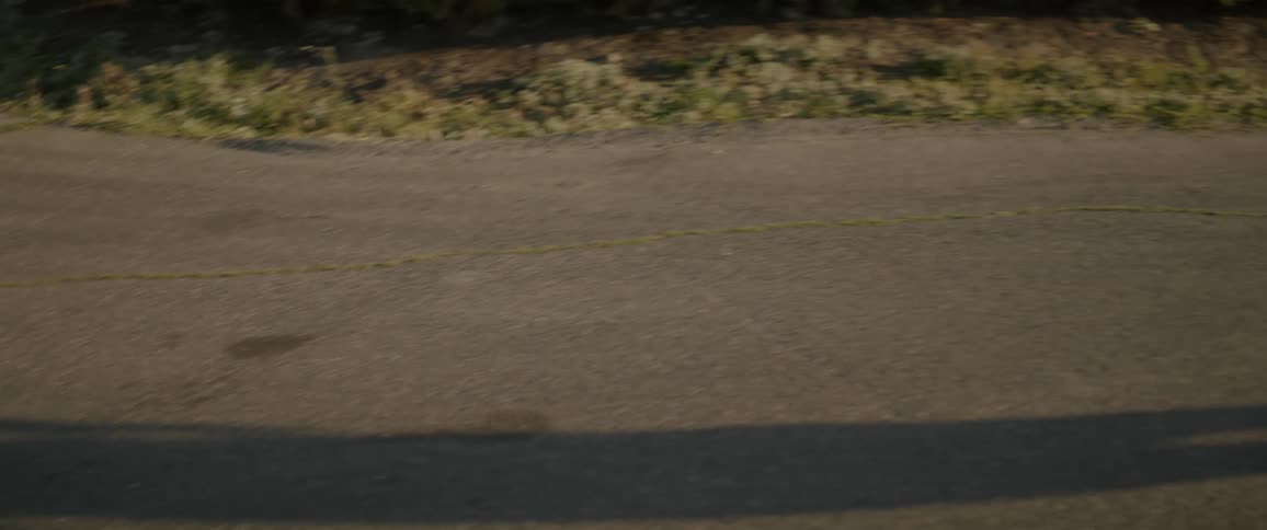 The person walks on the gravel giving off a shadow