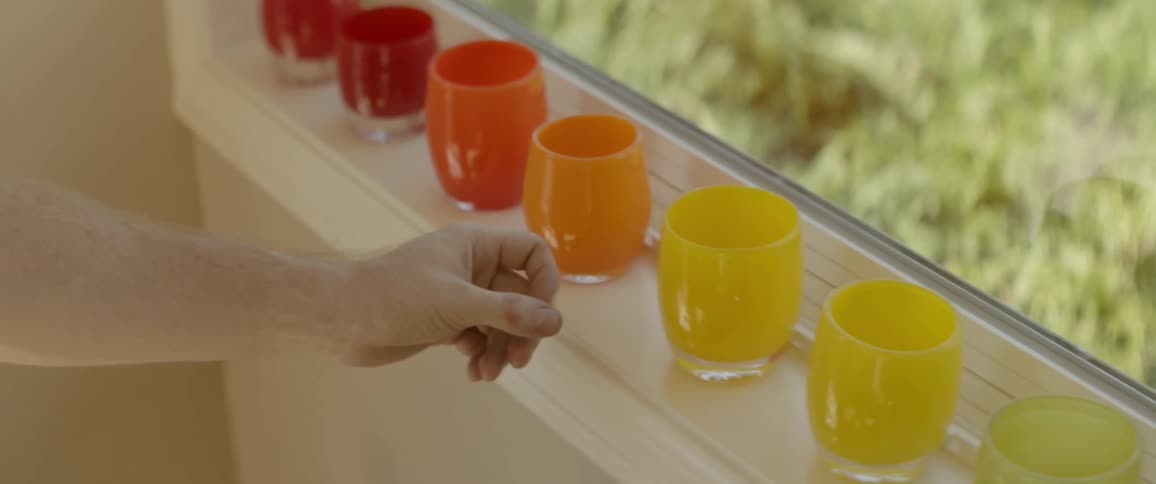 The person is tapping the glasses on the windowsill