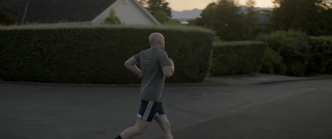 The man runs down the neighborhood corner