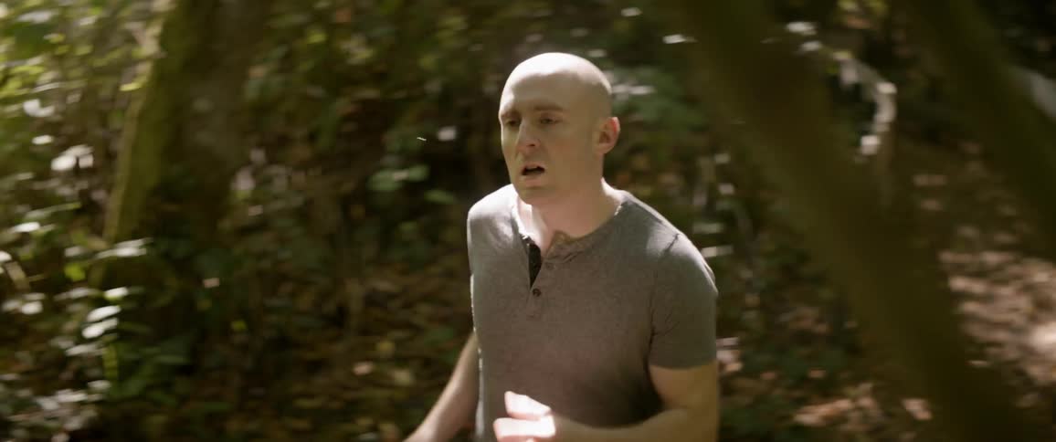 The man runs in the woods on a sunny day