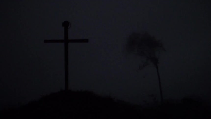 A cross in a foggy area at night
