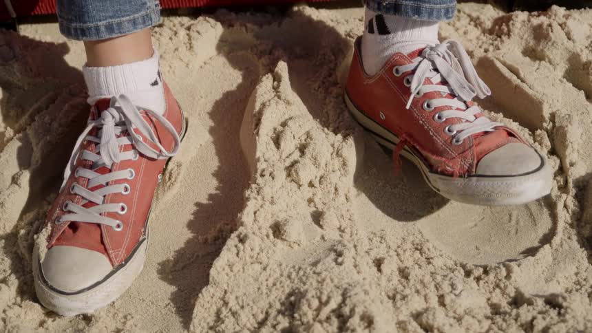 Person sitting on the beach tapping foot