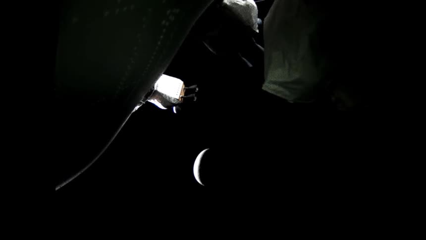 White shapes warp and flex against black space with moon