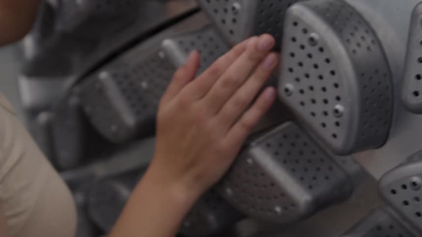 A close up of a womans hand rubbing a metal object while she has her eyes closed