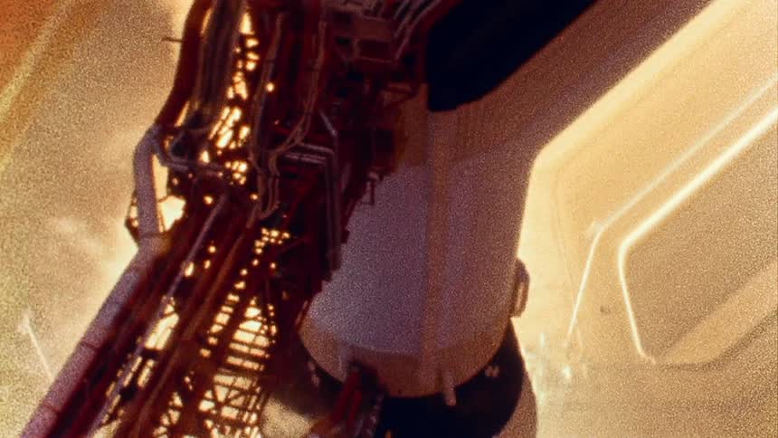 Archival footage of the apollo rocket on the launch tower caught on vintage film