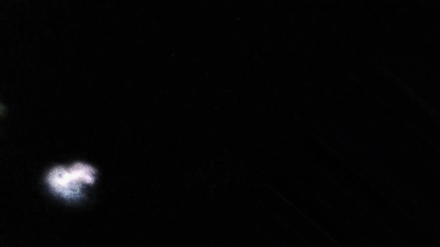 Distorted footage of lightning rolling on clouds at night