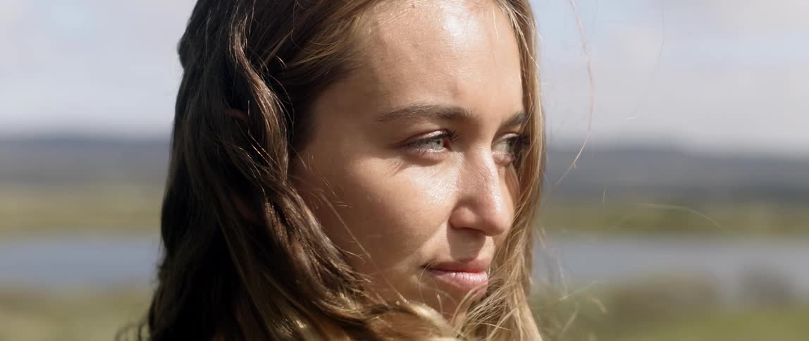 Woman is staring off outside on windy day