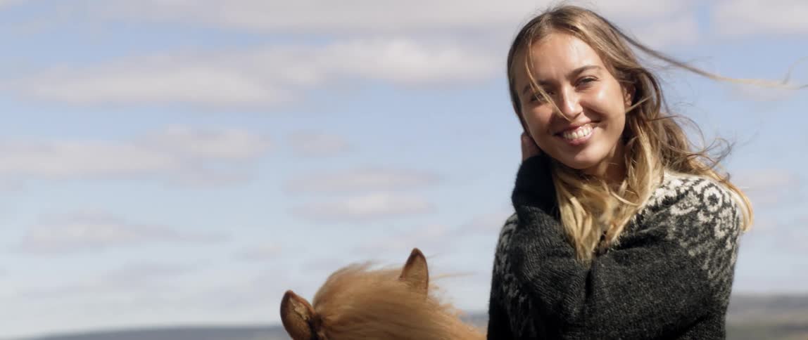 A woman stands by a horse