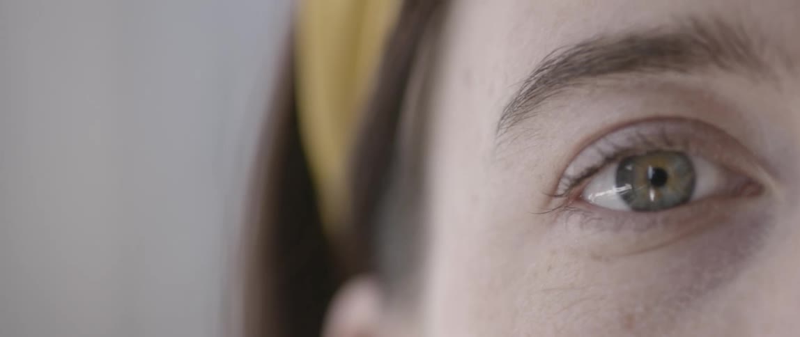 A young woman blinks her eye