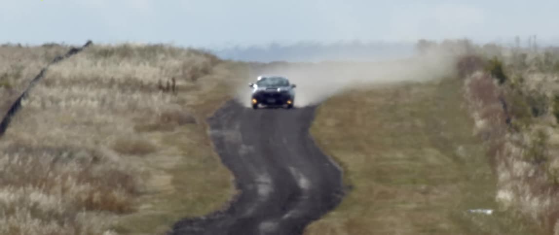 A vehicle drives on the winding road