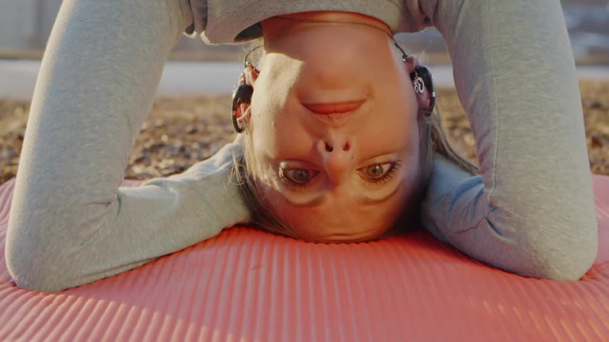 The woman is doing a headstand on the beach