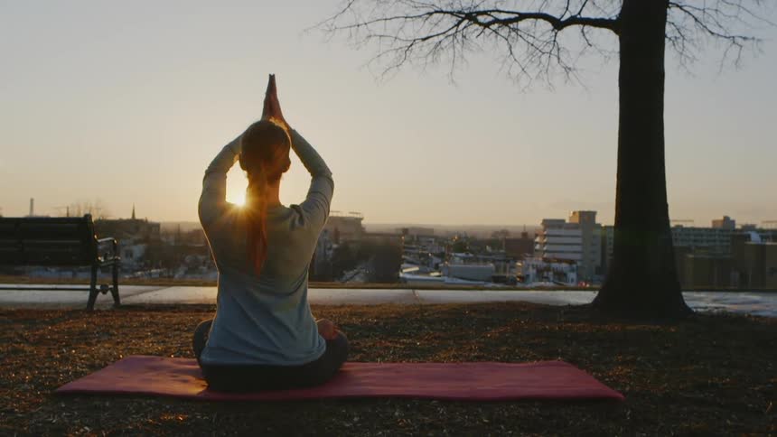A woman does yoga outside