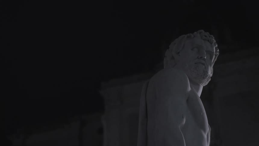 A statue of a bearded man at night