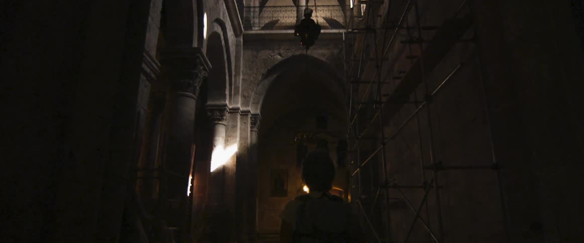 A person walks through a dark hall