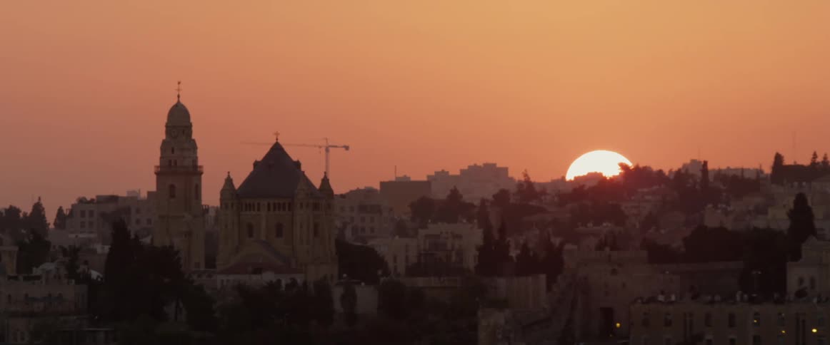 Sunsets behind a hillside covered with homes and buildings