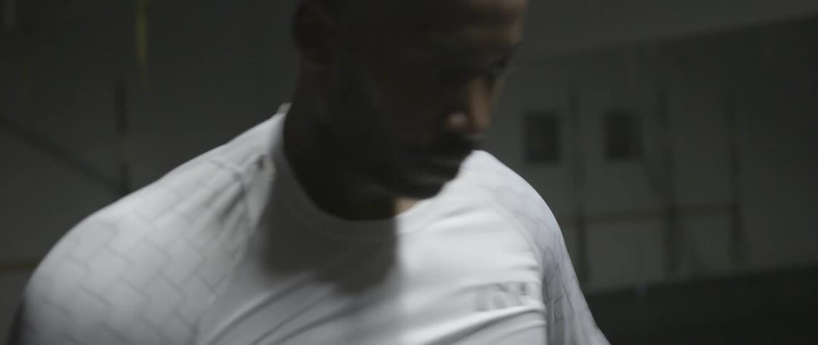 A man puts on a white shirt and stretches