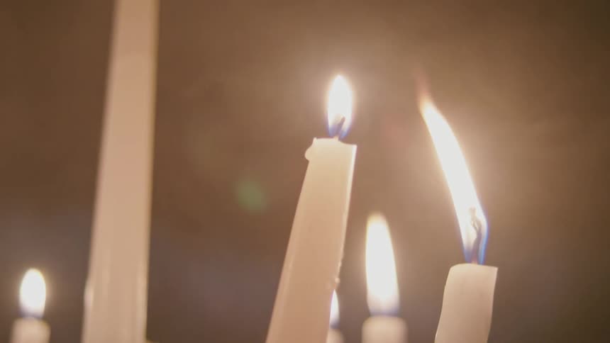 Flickering candles send up wisps of smoke