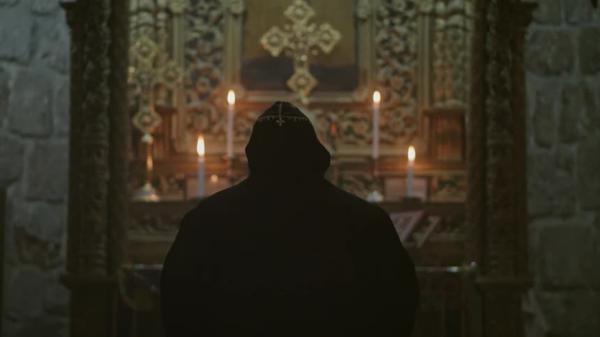 A priest is praying at an altar