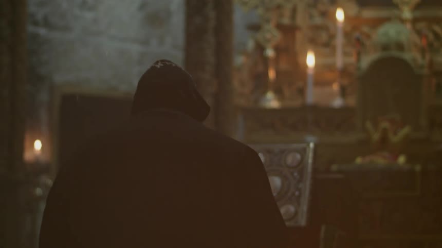 A priest is standing near the altar