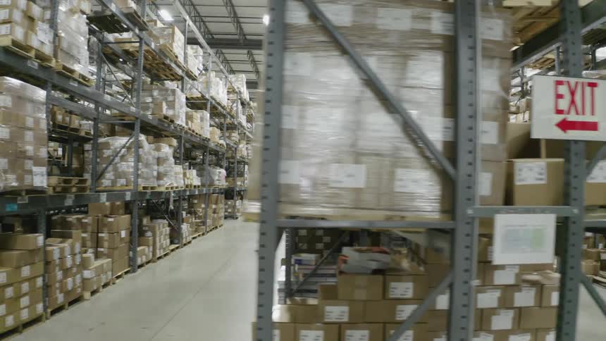 Person stands in center of aisle in a warehouse