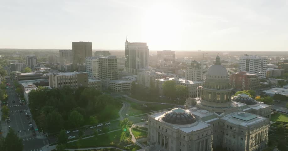 Traffic moves along streets bordering domed government building