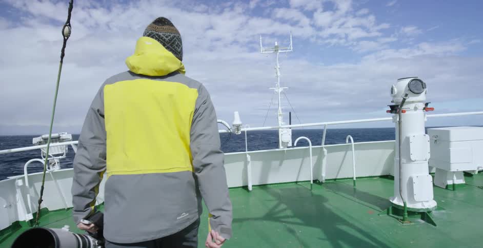 A man walks up to a boat rail