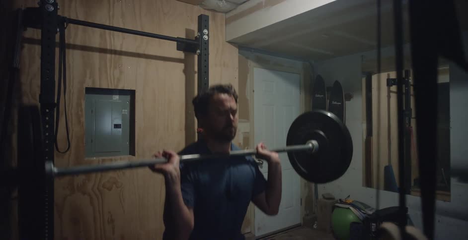A man lifts a barbell and then drops it