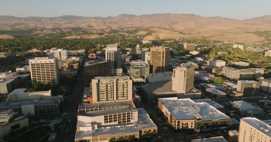 Traffic moves along streets of town bordering bare rocky mountains