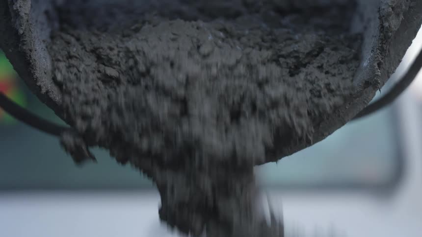 Cement or concrete pouring out of a cement mixer into an area