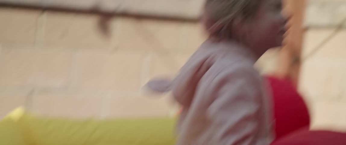 A little boy and girl play in a deflated jump house outside