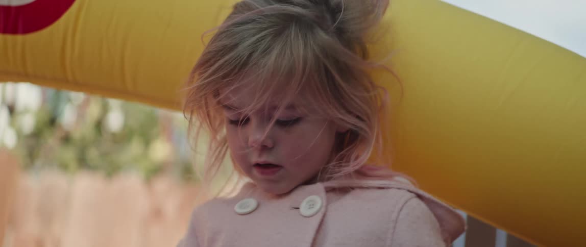 A child is outside on a windy day