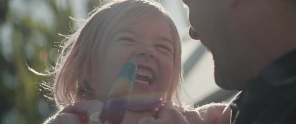 Father holds toddler daughter laughing together