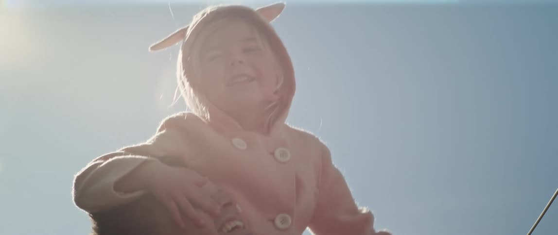 Little girl wearing pink bunny ears jacket sitting on daddys shoulders smiling laughing and pointing