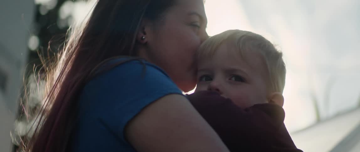 A mother gives her son a kiss