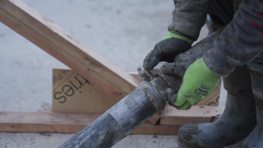 A worker attaches a clamp to the hose