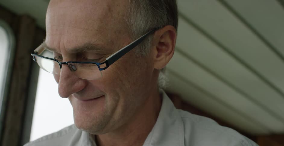 A man is smiling as he looks down