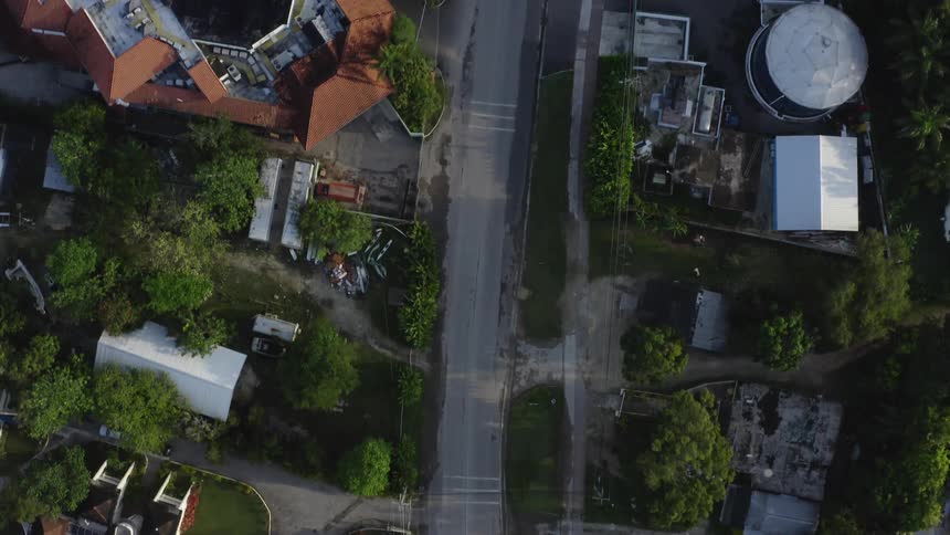Top down aerial view of cars driving down the street on the neighborhood
