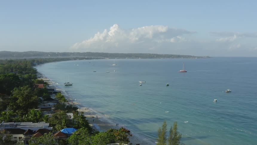 Aerial drone shot view of beach and boats off the coast of Jamaica