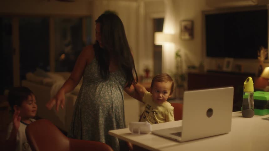 A mother and her sons look at a laptop together