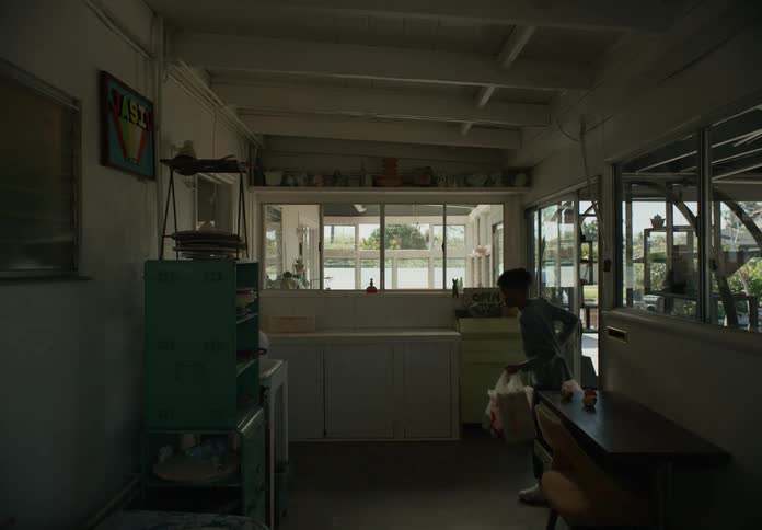 The inside of a home as brothers walk through the door one carrying grocery bags