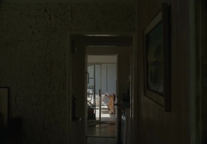 Kid jumps over object on floor in home as he walks through room