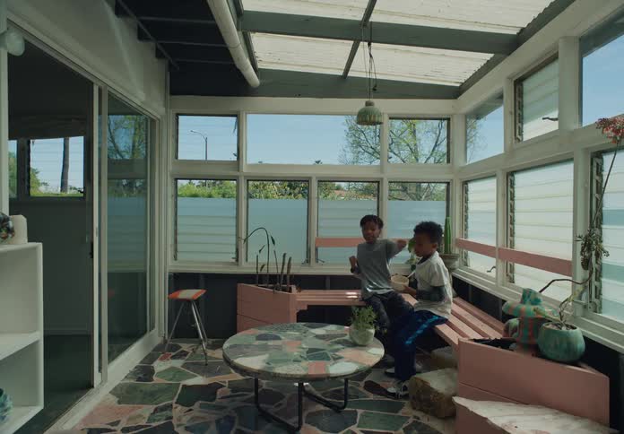 Two tween brothers hanging out in sunroompatio play fighting smiling shadow boxing