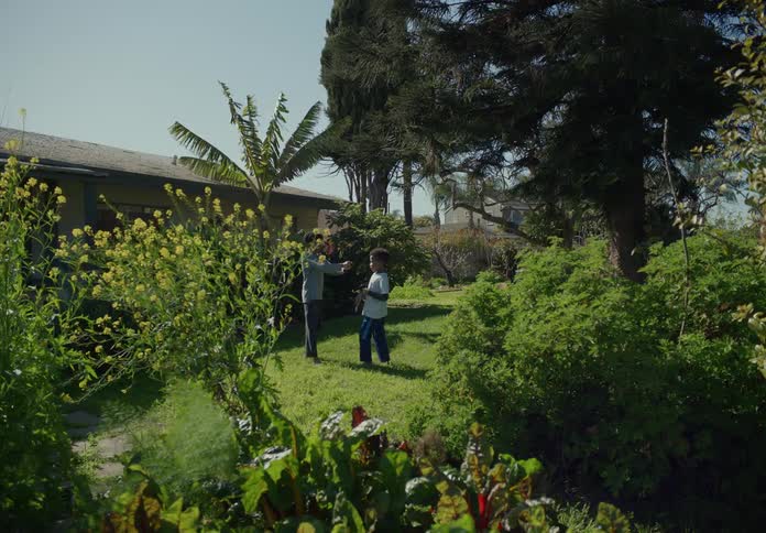 Young brothers play cop and robbers in the backyard at home