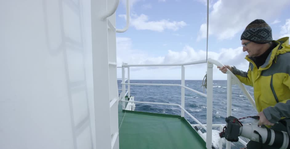 A man climbs to the upper deck of a ship