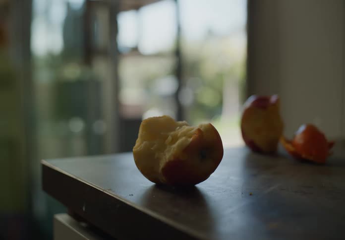 Apple cores and orange peel sitting on wooden counter top in kitchen during the day