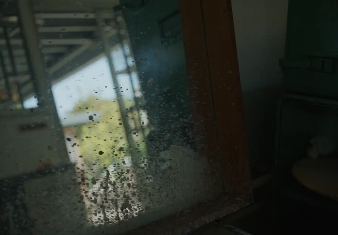 A dirty mirror reflecting the area that it sits in