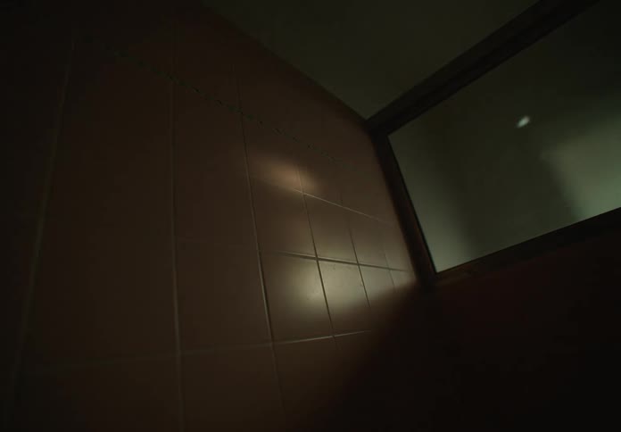 Ceiling corner of an empty bathroom with very little light coming in