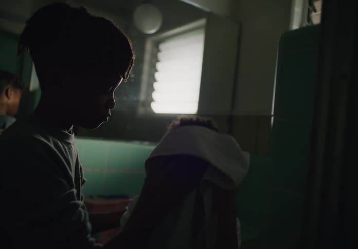 Older brother wipes face of his younger sibling before hanging the towel in the bathroom