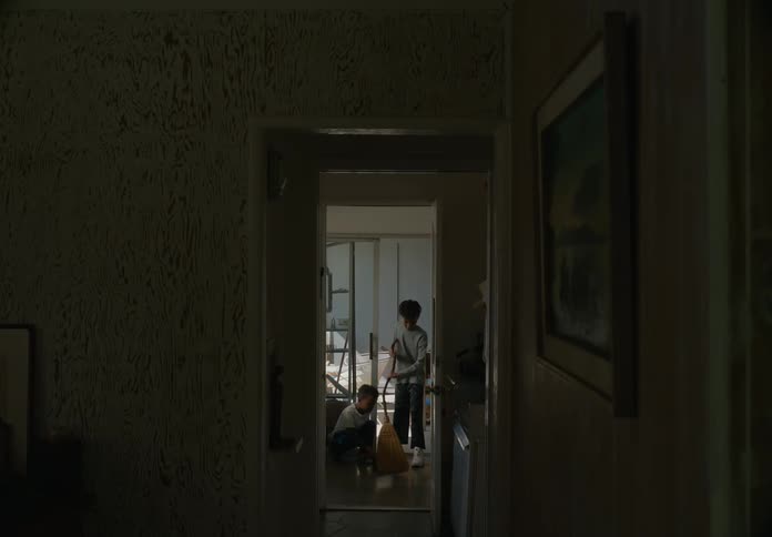 A at home takes a broom from his younger brother and sweeps the floor